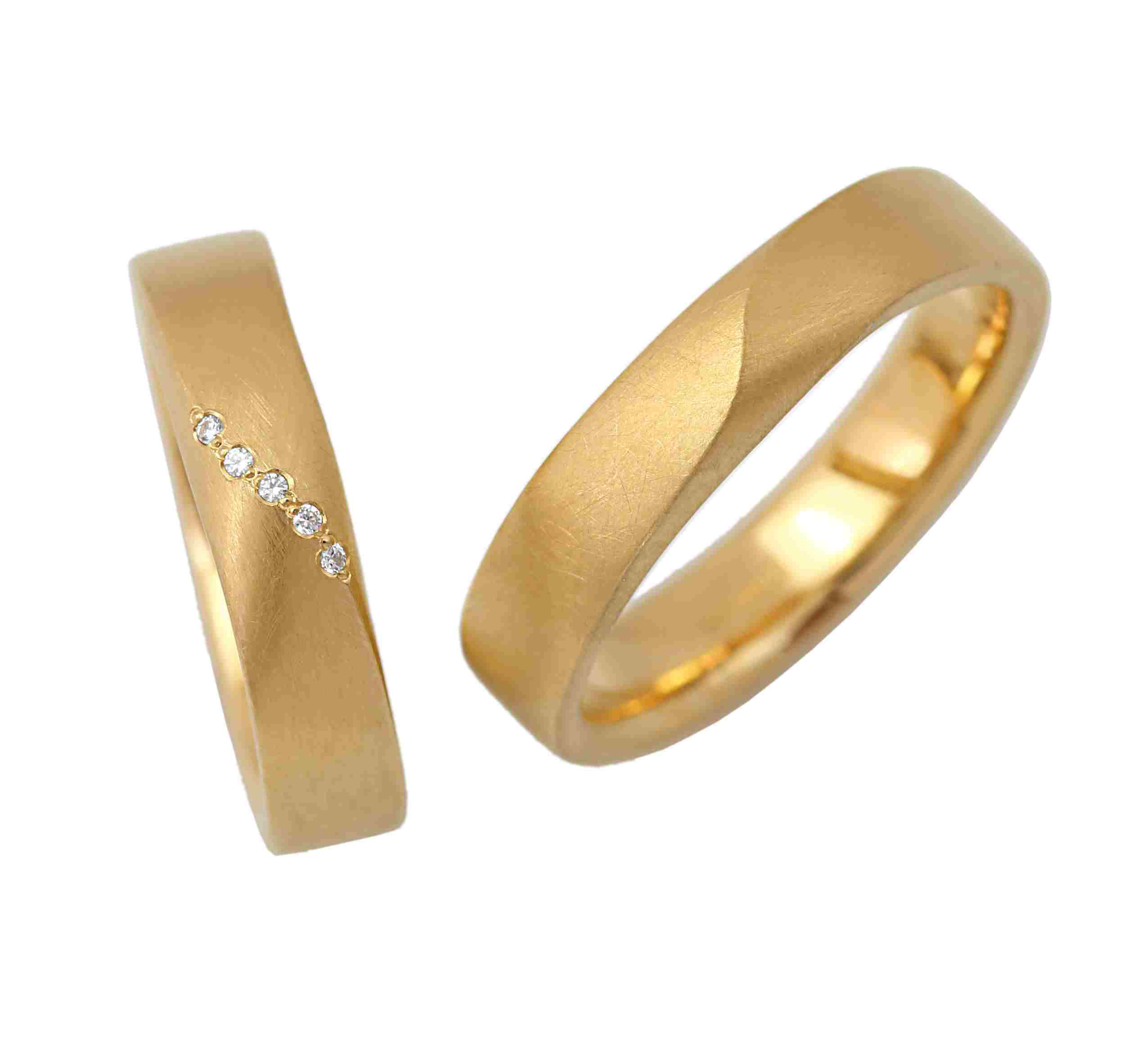 Processing:
Rolled, sawed, matte, polished, milled, stamped
Surface finish:
Matte, polished inside
Materials:
Yellow gold
Notable feature:
Elegant rings whose side surfaces become the main surface, creating a beautiful line
Shape:
Band ring, square profile
Category:
Friendship ring, wedding ring, partner ring, engagement ring
Style:
Modern, individual design
Ring width:
5mm
Material thickness:
2mm
Enchanting wedding rings, friendship rings, or engagement rings made of yellow gold with diamonds. The previously incidental side surfaces become the main surface and merge into an almost imperceptible line. The smaller ring features a line accented with a row of 5 diamonds. The rings are each 5mm wide. The material thickness is 2mm. The rings have a matte finish, with a polished inside. The edges are pleasantly rounded for a comfortable fit. They are sustainably produced and 100% made in Germany. The diamonds are sourced from conflict-free origins.